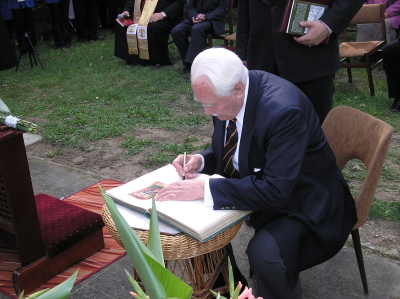 Prezydent wpisuje się do księgi pamiątkowej